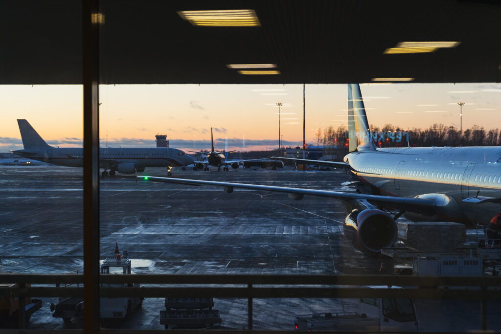 the view from the window on a parked passenger plane at sunset.